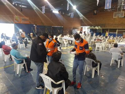 Personal de Salud toma los datos de personas aguardando para ser inmunizadas.