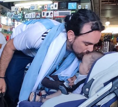 Tomás Centurión da un beso en la frente a su hijo de 5 meses Mirko que lo recibió en la Estación de Buses de Asunción este viernes.