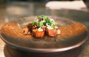 Vista de un plato confeccionado a base de berenjena frita con láminas de carne hecha por plantas en Singapur.
