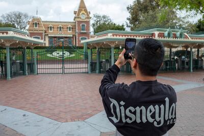 Un hombre toma una foto de la fachada de Disney, California, en el primer día de clausura del parque de atracciones, en marzo pasado.