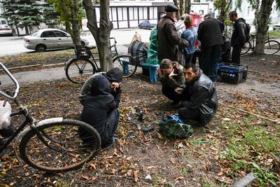 Residentes de la región ucraniana del Donbás, centro del conflicto con Rusia, aguarda un transporte para migrar de la zona.  (Juan BARRETO/AFP)