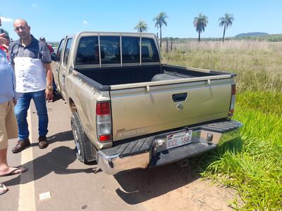 El subcomisario Sergio Barboza, de Investigaciones de Cordillera, junto a la camioneta baleada en el asalto en Tobatí.
