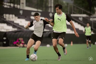 Julio Enciso y José Canale (con chaleco), ayer en el ensayo de fútbol el equipo del Libertad.