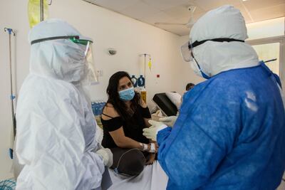 La joven venezolana Evelyn Leal (i) posa después de que el doctor Darlin Del Orbe, director del hospital Santo Socorro, le notificara que ha superado el COVID-19 y será dada de alta inmediatamente,  en Santo Domingo (República Dominicana).