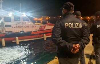 Policías en el muelle del puerto esperan la embarcación con los cuerpos de 8 migrantes en Lampedusa, Sicilia, Italia, 03 de febrero de 2023.