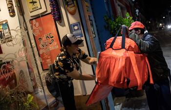 Marcelo da Costa Paula, de 50 años y trabajador de servicios de delivery, entrega un pedido el 29 de enero de 2023, en São Paulo (Brasil). Al igual que en otras zonas del mundo, la plataformas digitales de transporte (PDT) experimentaron un acelerado auge durante la pandemia de la Covid-19 en las principales economías de Latinoamérica y mantienen hoy un crecimiento sostenido, aunque con problemas similares de precariedad, explotación y leyes laborales con más sombras que luces.