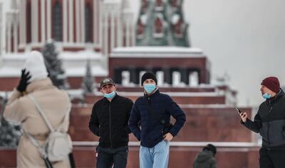 Varias personas pasean con mascarilla por la Plaza Roja de Moscú.