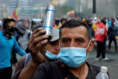 Un manifestante muestra un bote de gas lacrimógeno disparado por policías antidisturbios cerca de la Casa de la Cultura Ecuatoriana en Quito, el 21 de junio de 2022, en el noveno día consecutivo de protestas contra el gobierno. - La policía utilizó gases lacrimógenos para dispersar a unos 500 manifestantes, entre los miles que llegaron a Quito de todo el país en los últimos días, durante las protestas por el precio del combustible lideradas por indígenas que los militares describieron como una "grave amenaza".