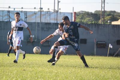 Hugo Santacruz intenta conservar la posesión de la pelota ante la marca del "franjeado" Mario Smith, Elvio Díaz acompaña la acción. (APF)
