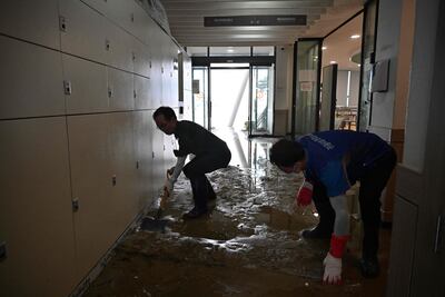 Workers clear debris from a tourist centre after Typhoon Hinnamnor passed through Busan on September 6, 2022. (Photo by Anthony WALLACE / AFP)