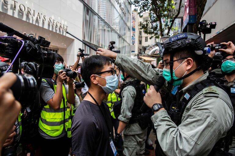 Un policía de Hong Kong ordena a un activista prodemocracia a despejar las calles durante una protesta, hoy. Jóvenes hongkoneses salen en defensa de sus libertades.
