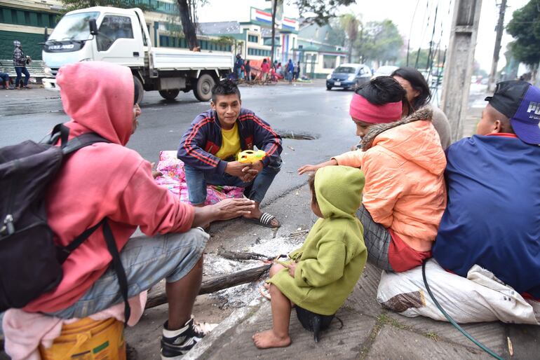 Niños y adolescentes se refugian en las fogatas para hacer pasar el frío.