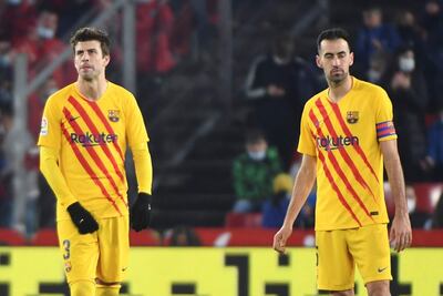 Los jugadores del FC Barcelona, Gerard Piqué (i) y Sergi Busquets, tras encajar el gol que ha significado el empate a uno definitivo durante el encuentro correspondiente a la jornada 20 de primera división que han disputado hoy sábado frente al Granada en el estadio Nuevo los Cármenes de Granada.