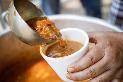 Un cocinero sirve hoy jopara, en la calle Palma en Asunción.