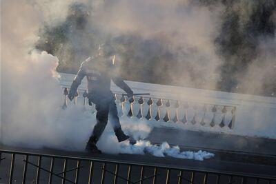 Un policía patea una granada de gas pimienta utilizado para dispersar a los manifestantes en Santiago (Imagen referencial).