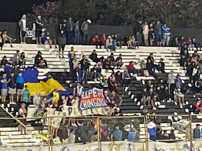 Los hinchas de Sport Colonial con una bandera de Cerro Porteño