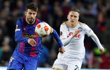 Garard Piqué (i) disputa el balón con el polaco Zielinski, autor del gol para Napoli.