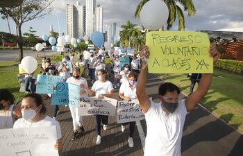 Padres de familia marchan mientras piden el regreso presencial de los estudiantes a clases, ayer martes.