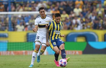El paraguayo Alan Rodríguez (d), de Rosario Central, disputa el balón con el uruguayo Miguel Merentiel, de Boca Juniors, durante el partido de ayer.