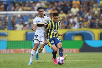 El paraguayo Alan Rodríguez (d), de Rosario Central, disputa el balón con el uruguayo Miguel Merentiel, de Boca Juniors, durante el partido de ayer.