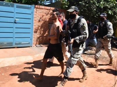 Agentes de la Policía Nacional escoltan a una de las personas detenidas este viernes en Capiatá.