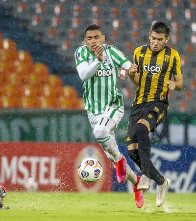 Campo pantanoso, lluvia constante y  pelea por la pelota como se lo hacen Villalba y Alvez.
