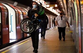 Un viajero lleva una máscara facial mientras camina en la plataforma de una estación de metro en Londres el 5 de junio de 2020