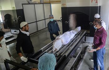 El cuerpo no reclamado de un hombre que murió de coronavirus en la India, a punto de ser incinerado en un horno crematorio.