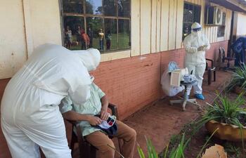 Profesionales de blanco asistieron a nativos de la comunidad indígena Aché con la toma de muestras de COVID-19.