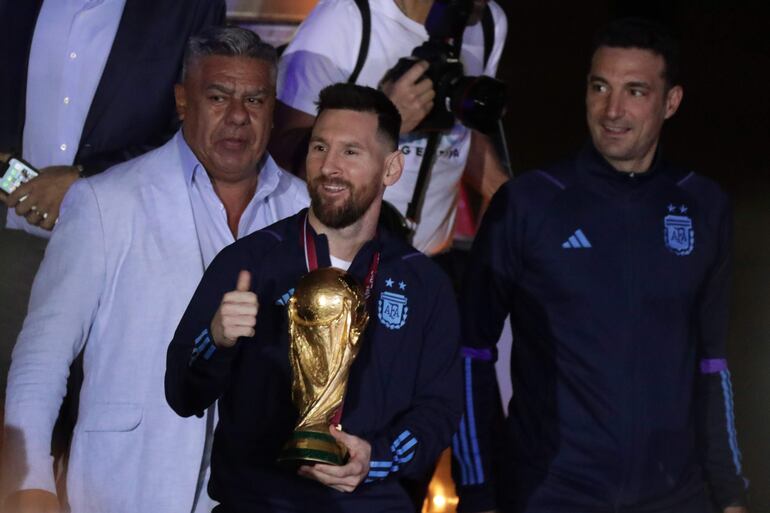 Lionel Messi bajando del avión con la Copa del Mundo en mano en el regreso de Argentina después de conquistar el Mundial Qatar 2022. 