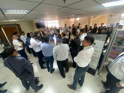 El grupo de ujieres se encuentran frente a la torre, en el piso, del Palacio de Justicia de Asunción.