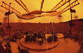 Vista panorámica de la multitud que rodea el escenario donde toca Carlos Santana en el Festival de Woodstock, fotografía de Jim Marshall, 1969.