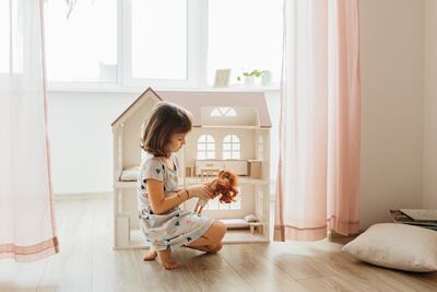 Niña jugando con una muñeca.