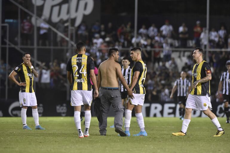 El hincha de Guaraní que ingresó al campo es sujetado y retirado por la seguridad privada de La Huerta.