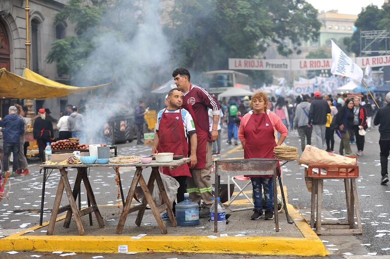 Vendedores ofrecen sus productos de comida a los asistentes al acto de Cristina Fernández. 