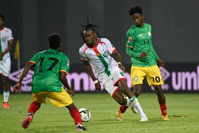 Bertrand Traore (c), delantero de Burkina Faso, intenta abrirse paso entre dos jugadores de Etiopía.
