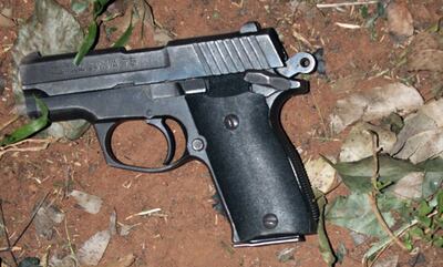 El arma de fuego del fallecido, que fue encontrada a centímetros del cadáver.