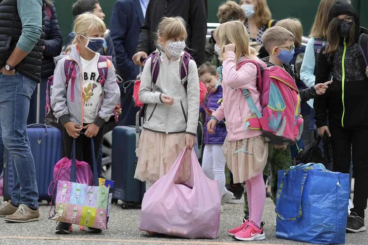 Alumnas con tapabacos forman fila para ingresar a la escuela en Estrasburgo, Francia.