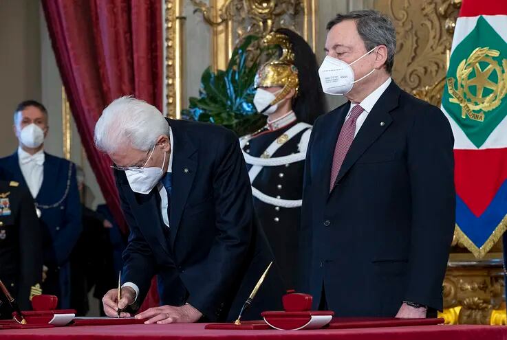 Esta foto hecha el 13 de febrero de 2021 en el Palacio Presidencial Quirinale muestra al presidente de Italia, Sergio Mattarella (izquierda) y al primer ministro de Italia, Mario Draghi (derecha) durante una ceremonia formal de juramentación del nuevo gobierno de Italia.