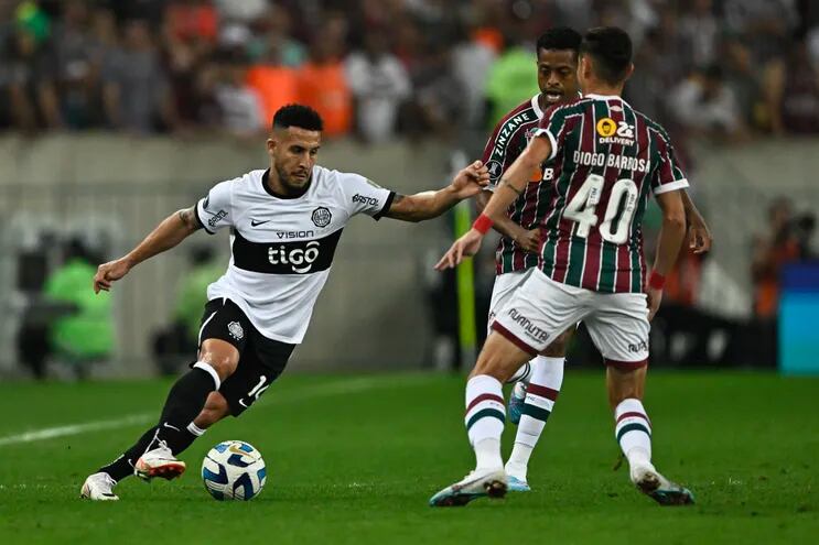 Fernando Cardozo, de Olimpia, encara la marca de los jugadores de Fluminense.