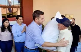 El vicepresidente de la República, Pedro Alliana, entrega una bolsa de víveres a un reciclador del vertedero municipal de Pilar. En total fueron entregados 15 kits de víveres.