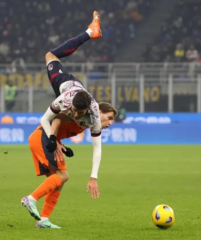 Oussama El Azzouzi, jugador del Bologna, queda suspendido sobre el cuerpo del interista Nicolo Barella, durante el partido de ayer.