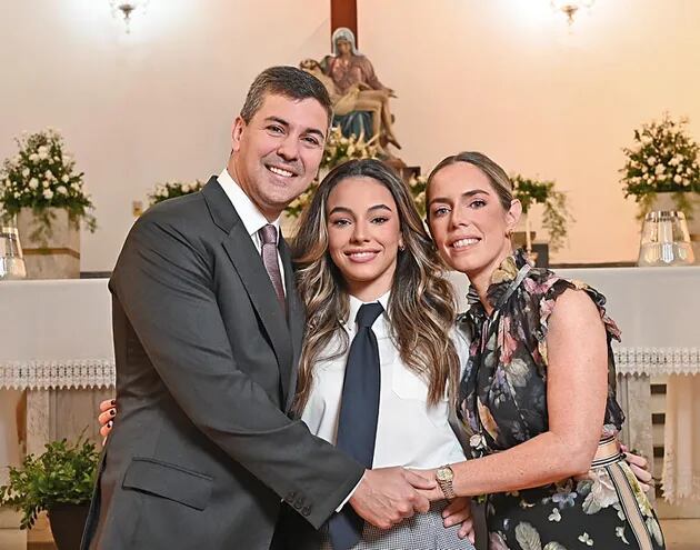El presidente de la República, Santiago Peña, y su esposa Leticia Ocampos abrazan a Costanza, la joven que culmina sus estudios secundarios.