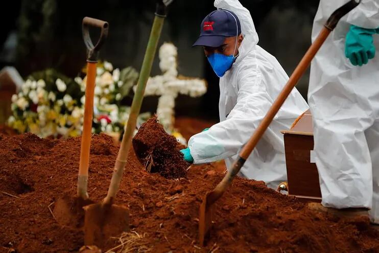 Trabajadores entierran a una víctima de covid-19 en el Cementerio Viola Formosa de Sao Paulo (Brasil).