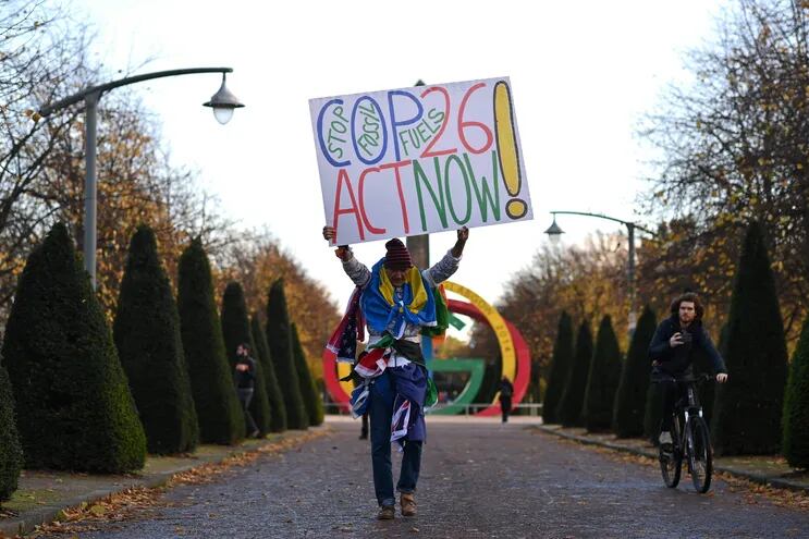 Un activista sostiene un cartel a su llegada a una actividad organizada por el movimiento Extinction Rebellion en Glaswgow.