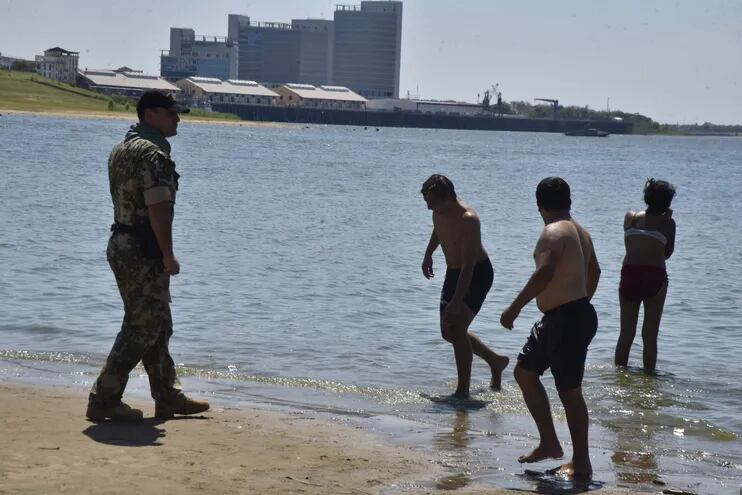 Un militar del Palacio de López retirando a una familia de las aguas contaminadas.