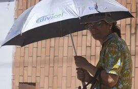 una-mujer-se-protege-del-sol-bajo-un-paraguas-varios-sufren-lesiones-en-la-piel-por-la-exposicion-solar--205500000000-1642277.jpg