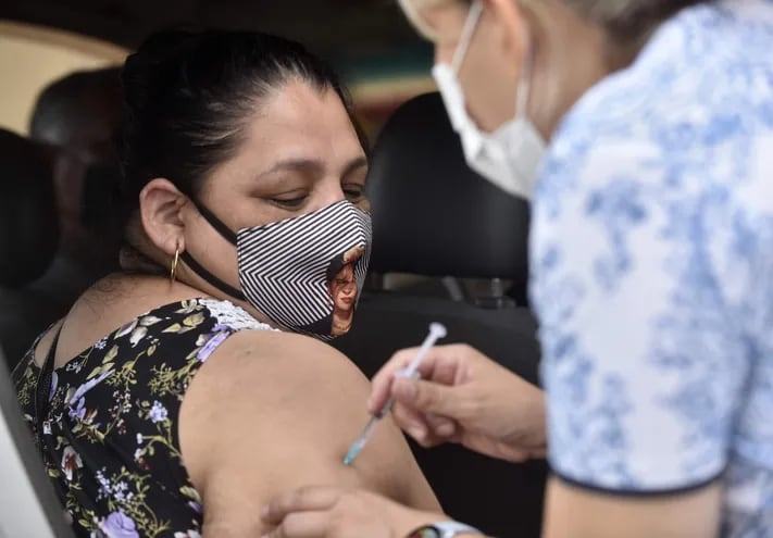 Mujer recibe dosis contra el COVID-19 en Asunción.