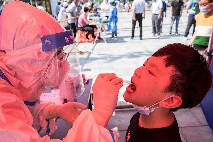 La foto tomada el 30 de julio de 2021 muestra a un niño recibiendo pruebas de ácido nucleico para el coronavirus, en Huaian, en la provincia de Jiangsu, en el este de China.