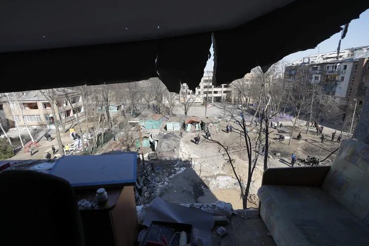 Ucranianos inspeccionan un edificio parcialmente dañado por misiles rusos en Kiev (Kyiv), Ucrania.